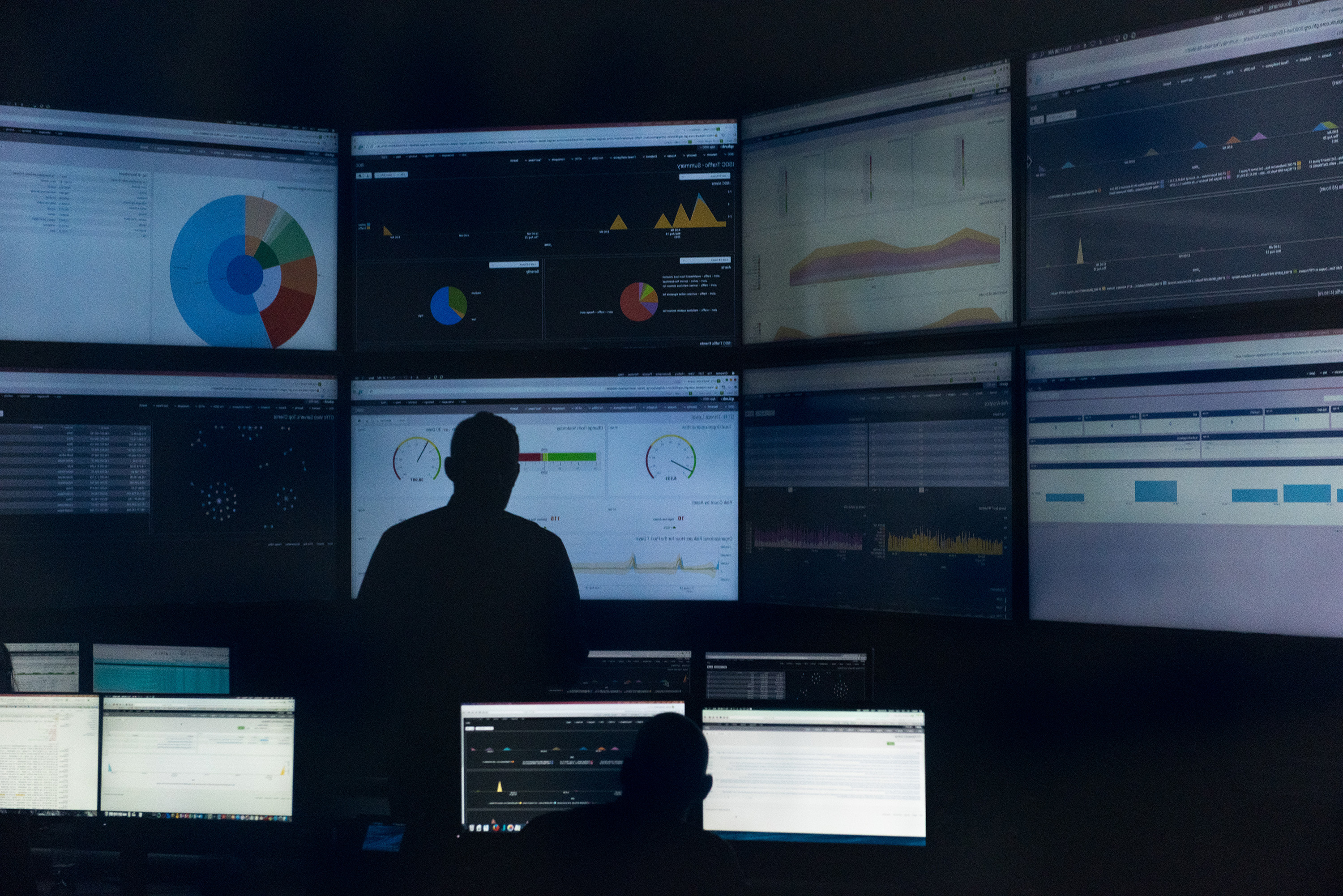 Researcher in front of eight monitors