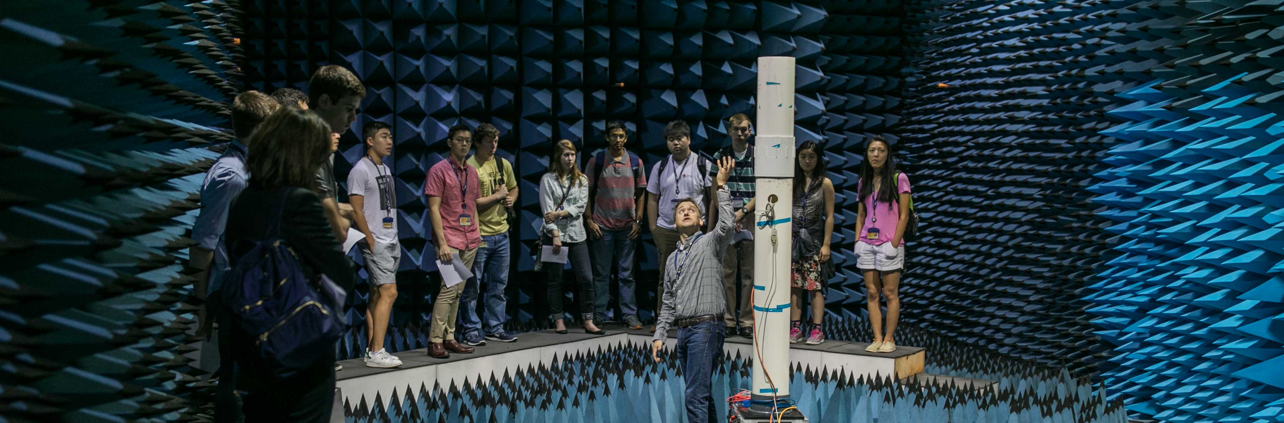 Students receiving instruction from teacher inside anechoic chamber
