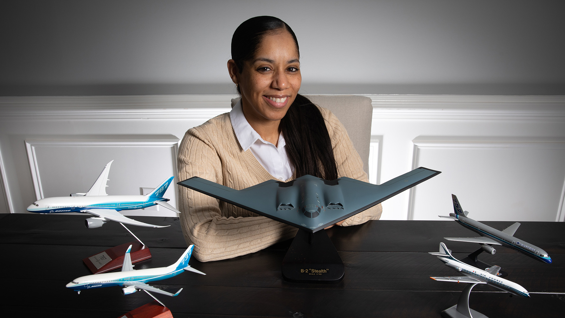 Sharaé Meredith sits behind five model aircraft