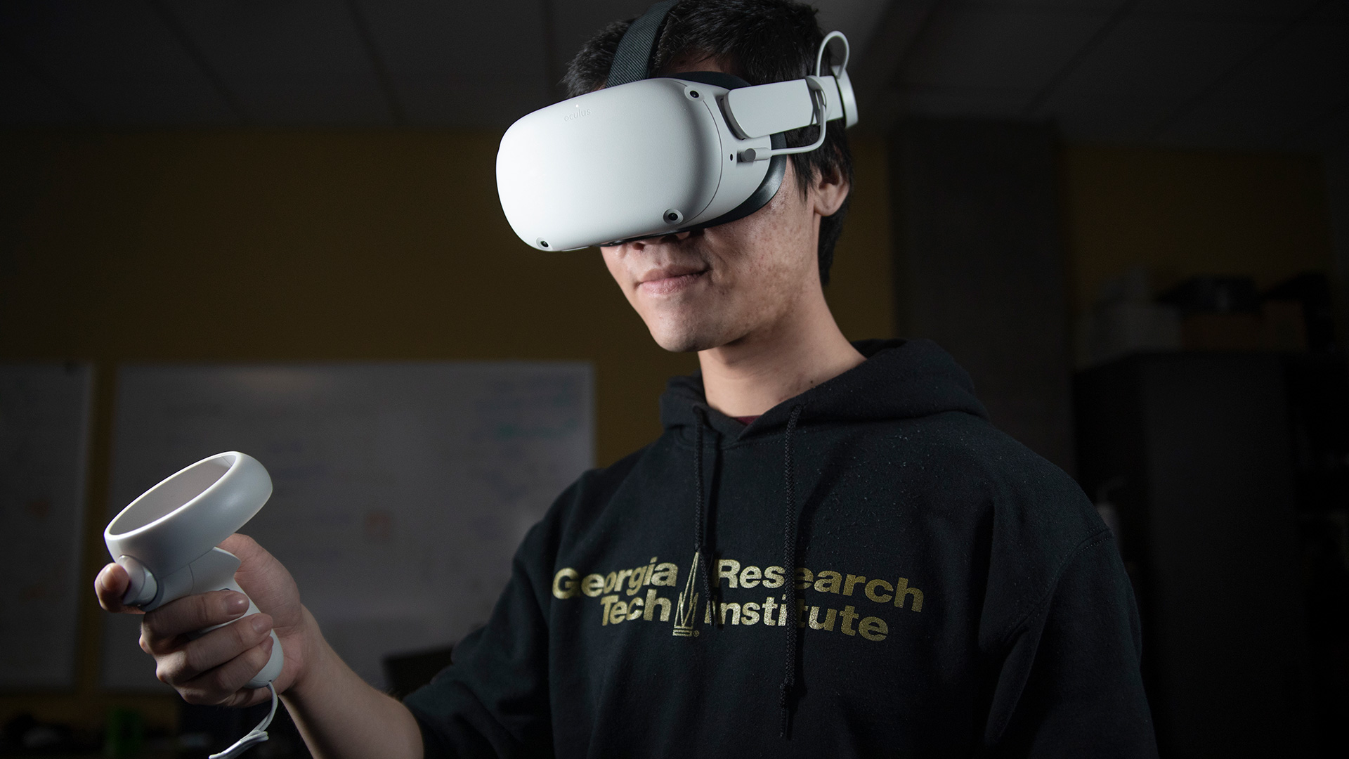 Researcher wearing VR goggles and holding VR wand.