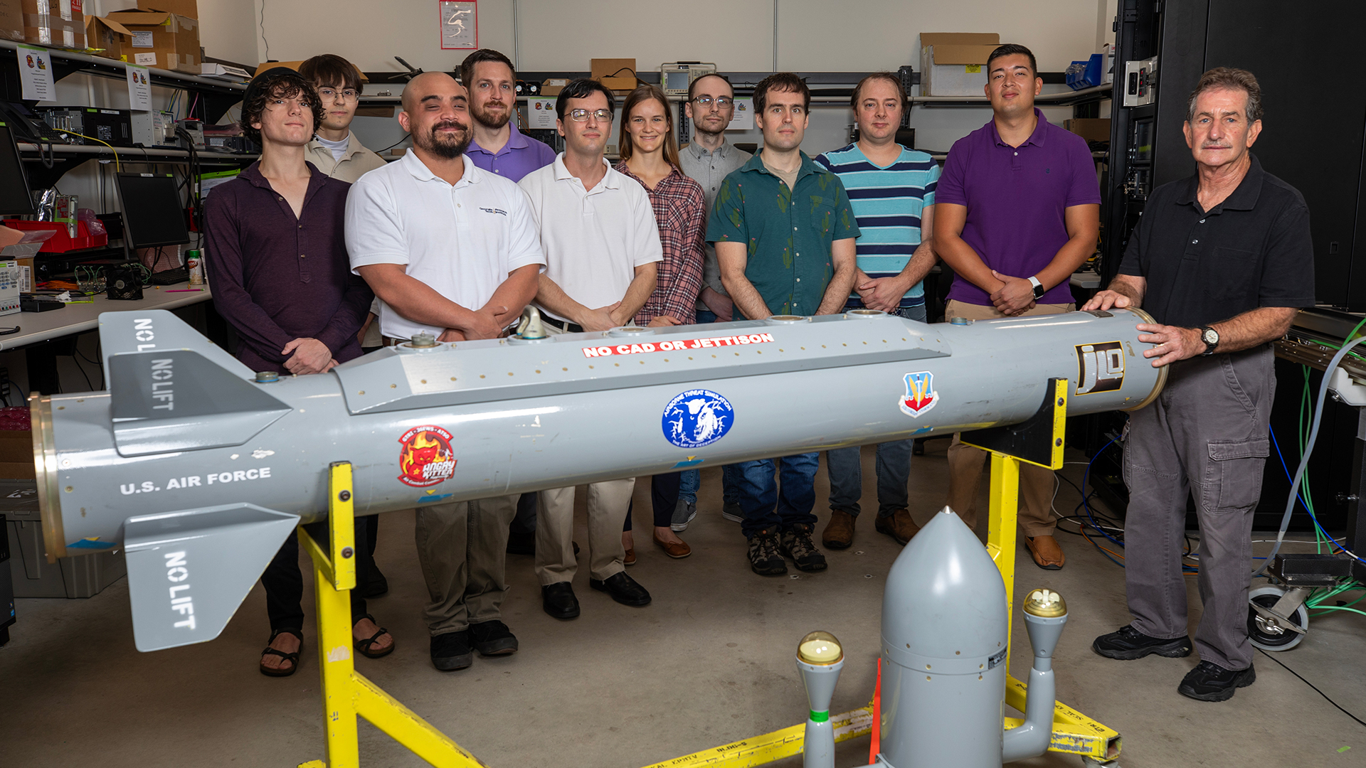 Group of researchers standing behind a device.
