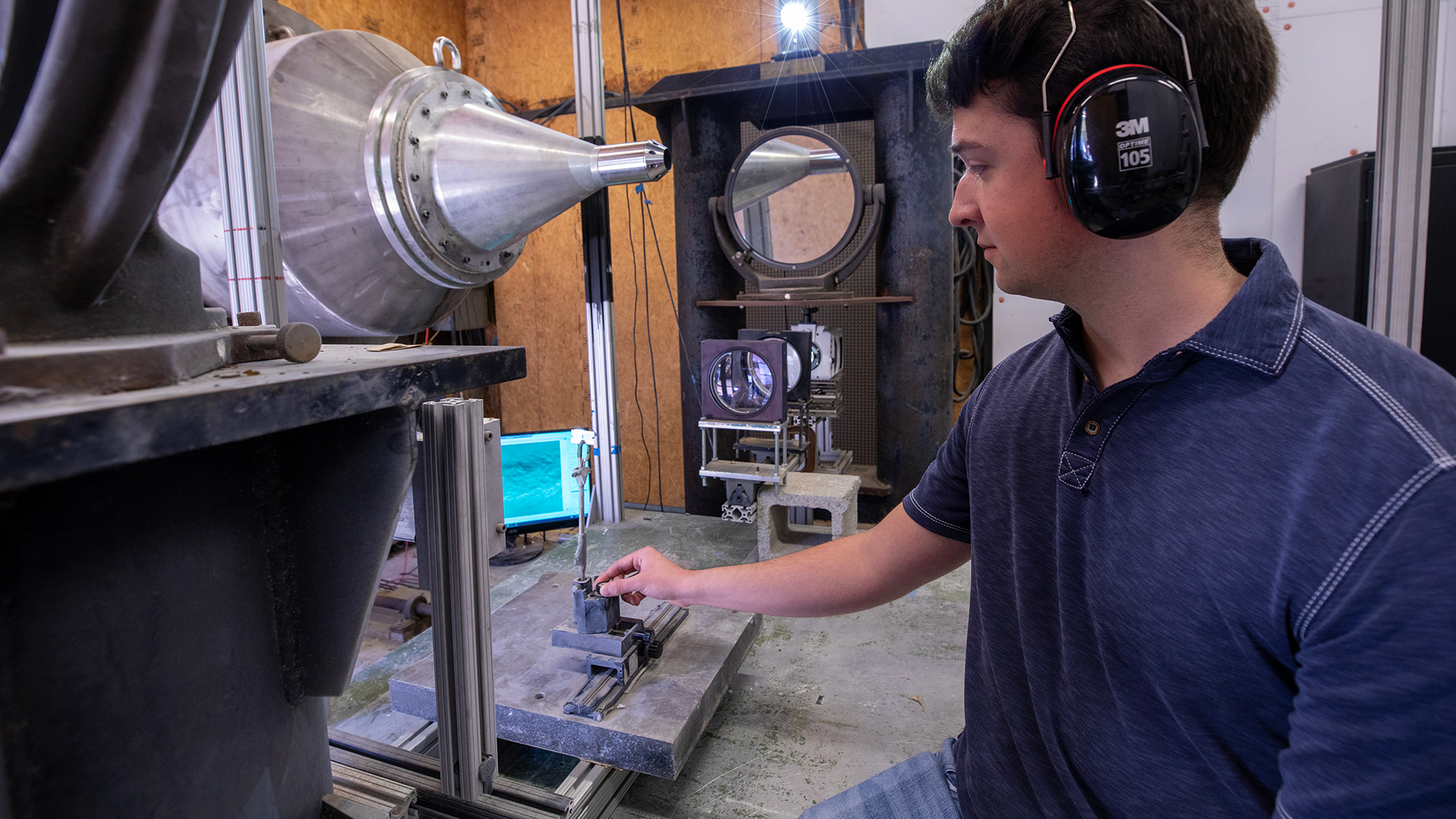 Researcher wearing headphones in testing warehouse facility.