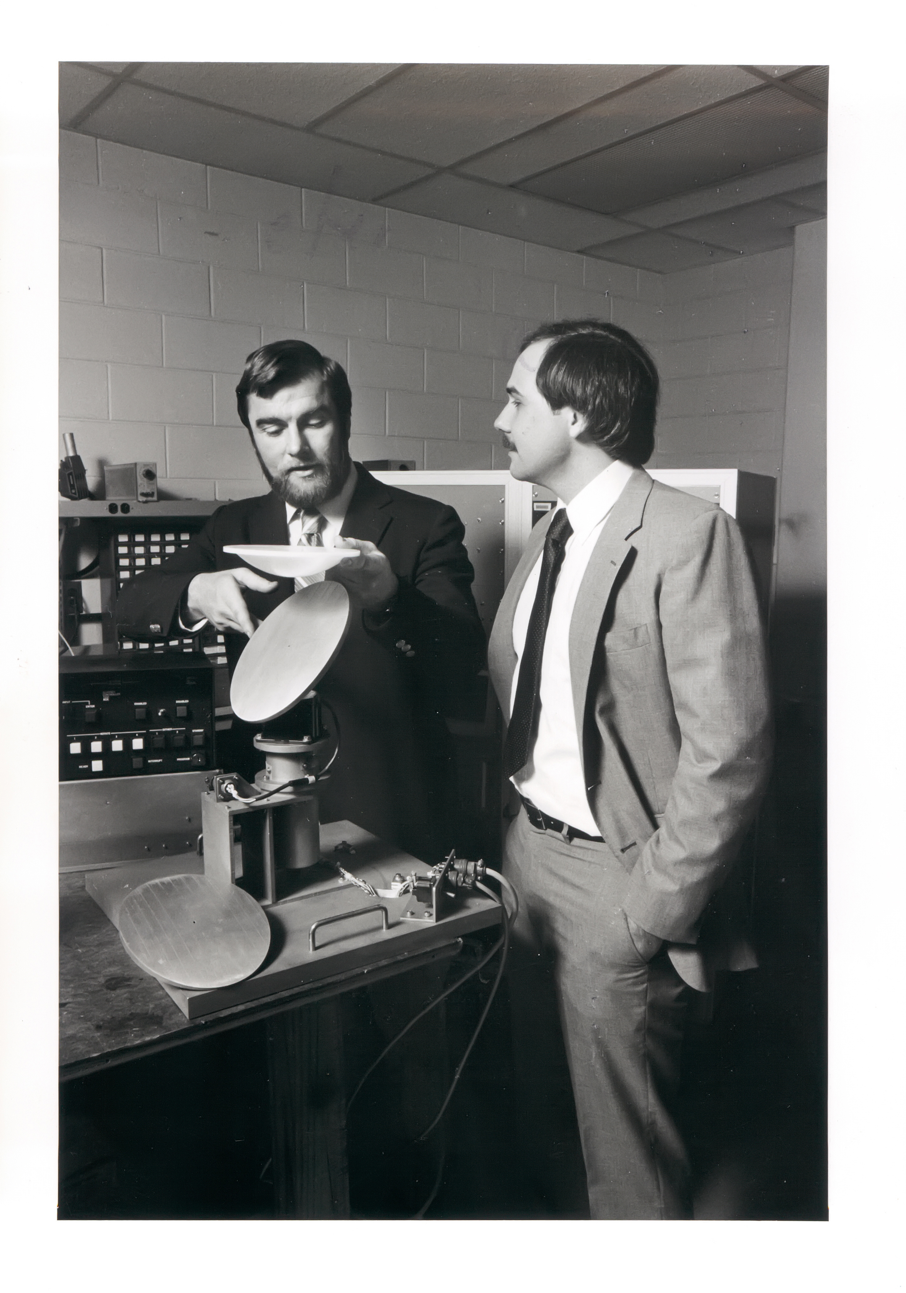 Black and white photograph of two GTRI researchers inspecting radar equipment in a laboratory