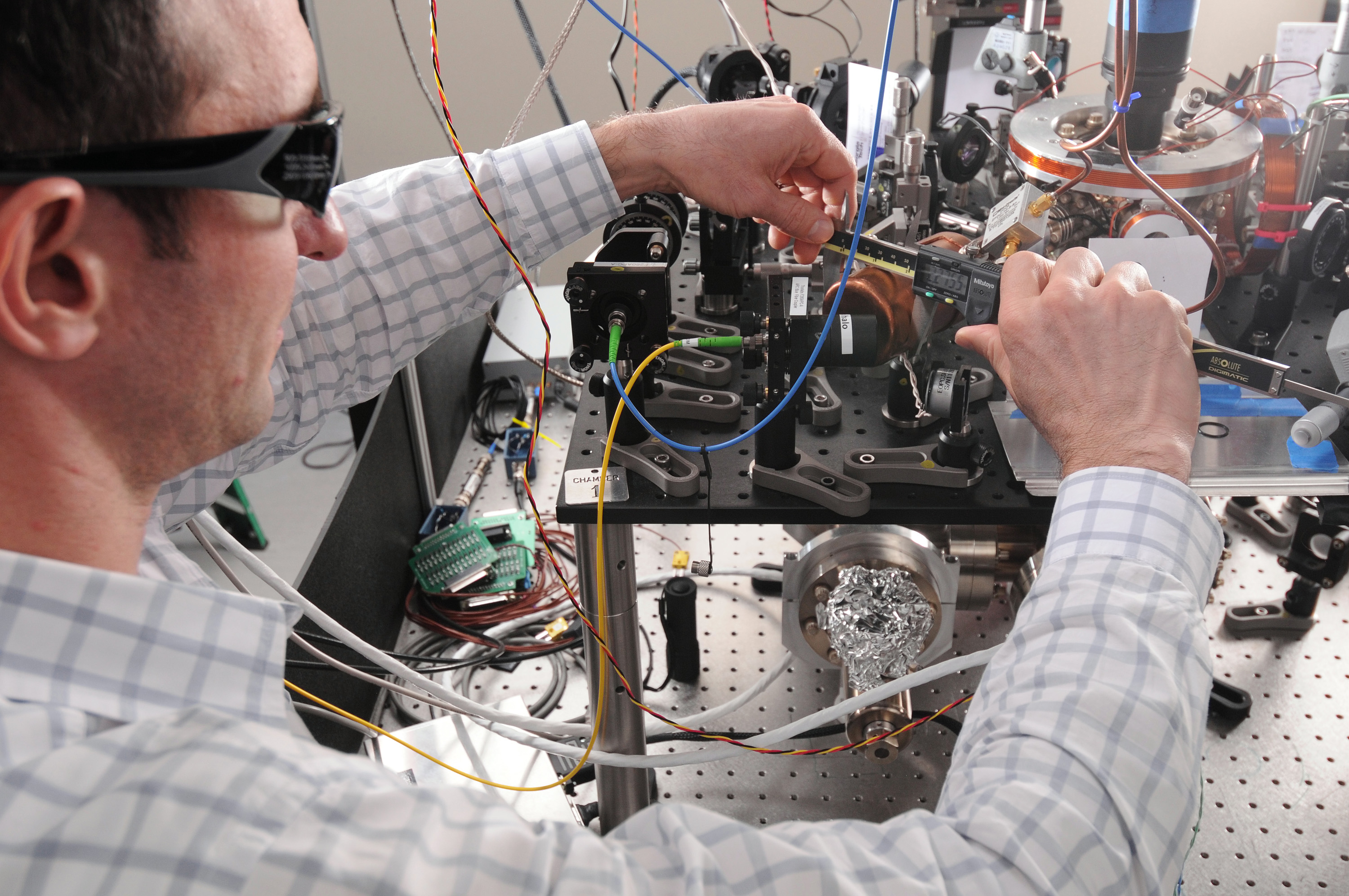 researcher adjust optical components in an experimental setup