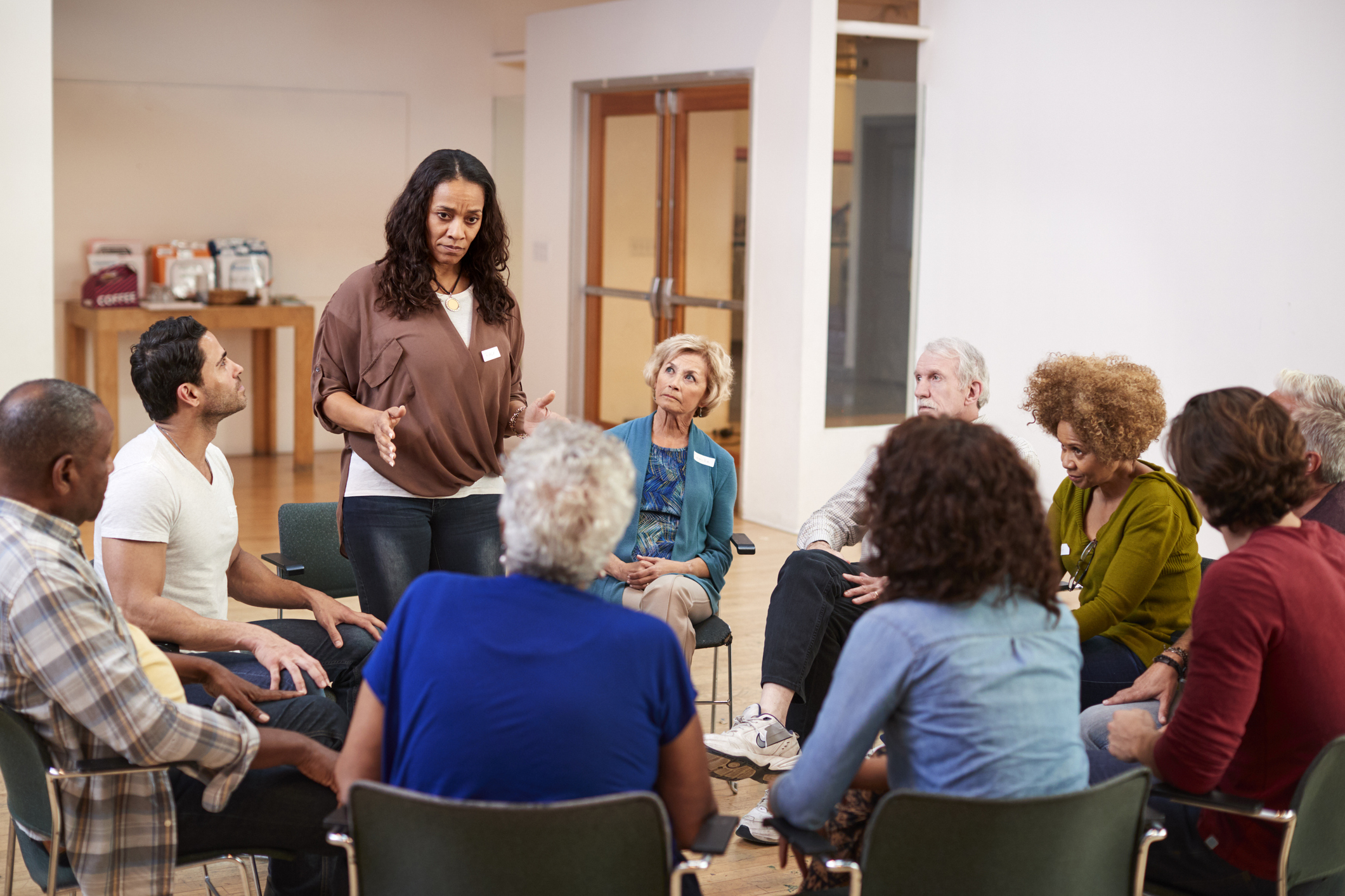 Group of people in chairs and an individual standing up giving instruction