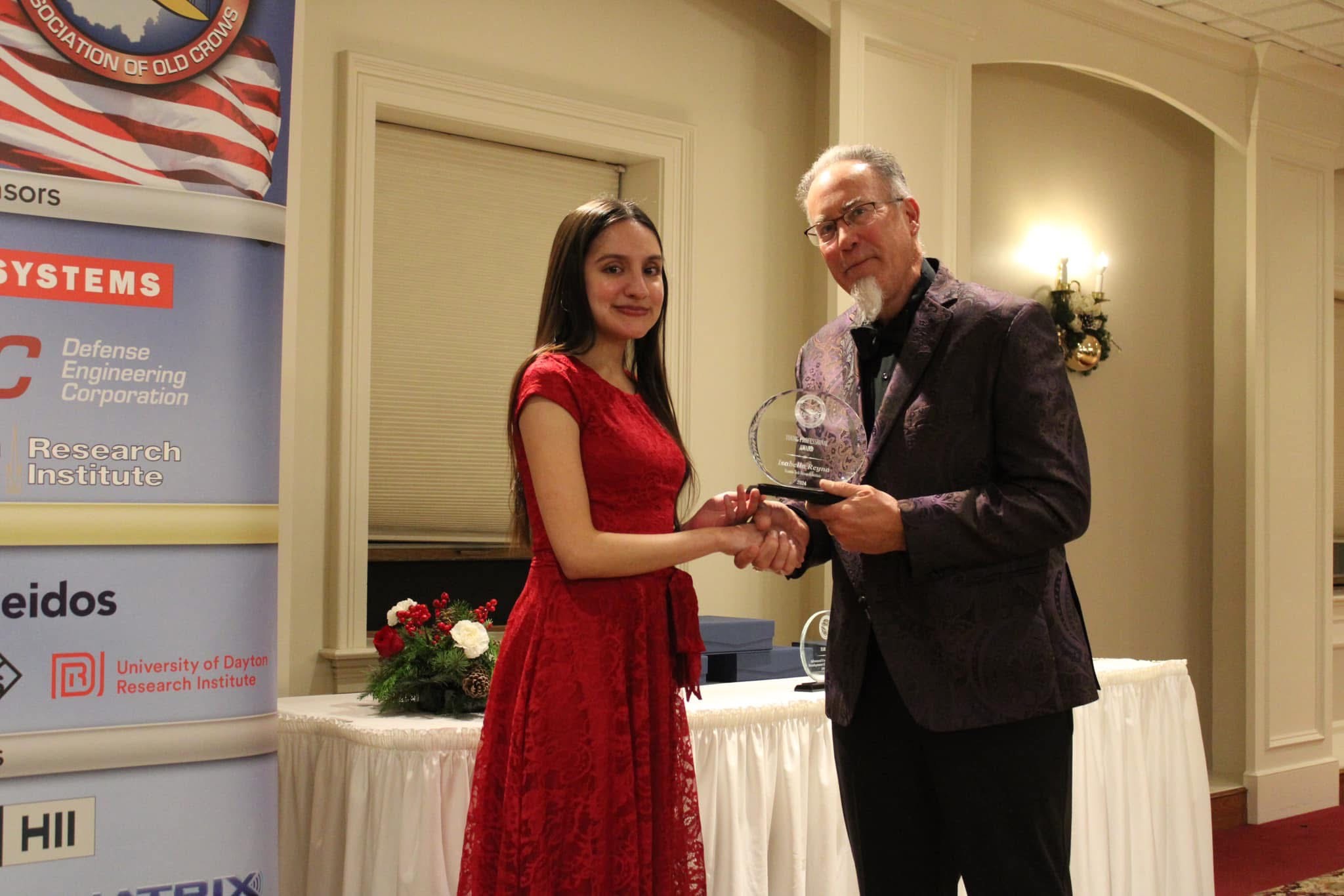 Isabella Reyna--accepting the award from Todd Kastle at the Association of Old Crows (AOC) Christmas party.