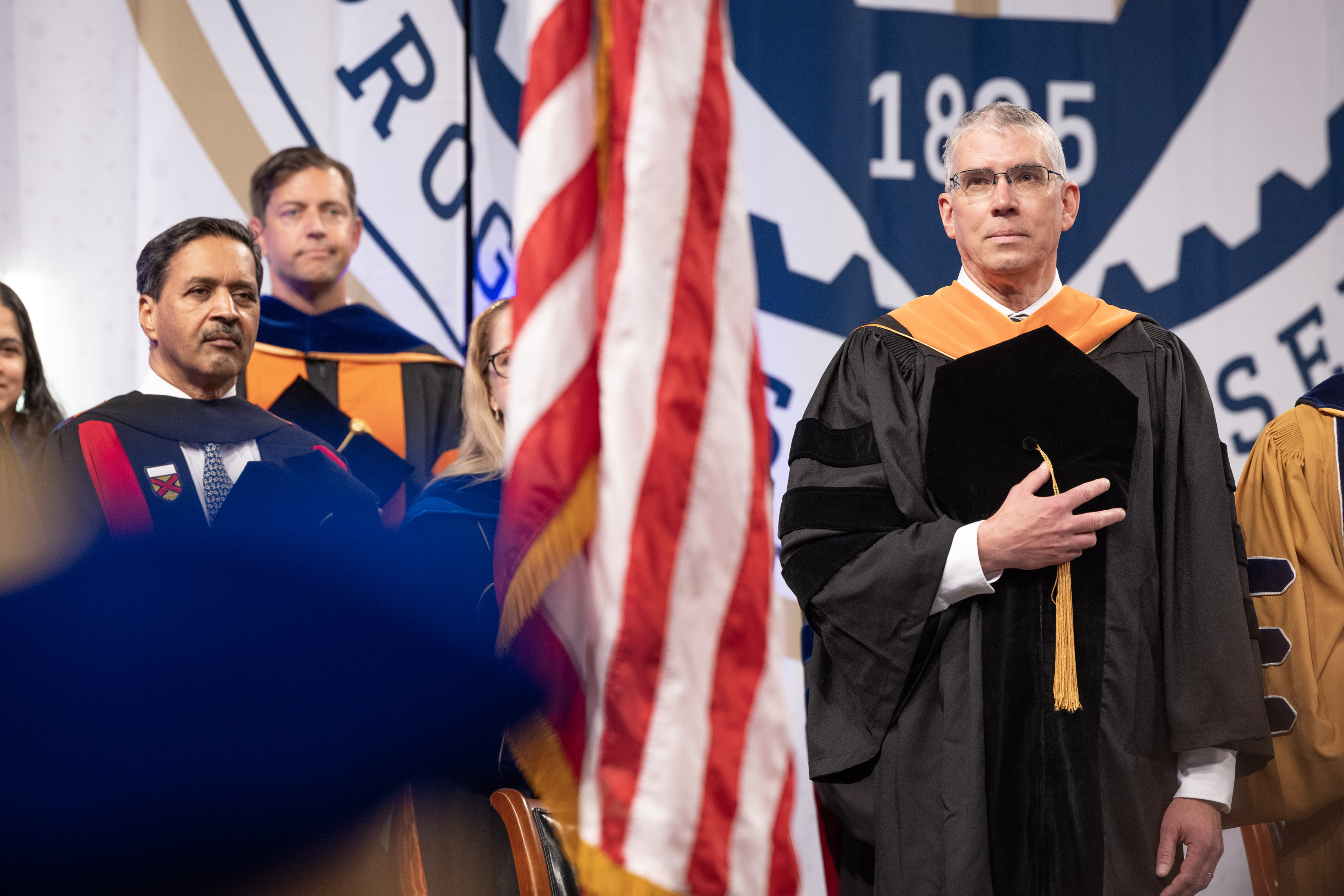 GTRI Director Mike Gazarik in academic regalia with hand over heart during Georgia Tech Spring 2026 commencement ceremony.