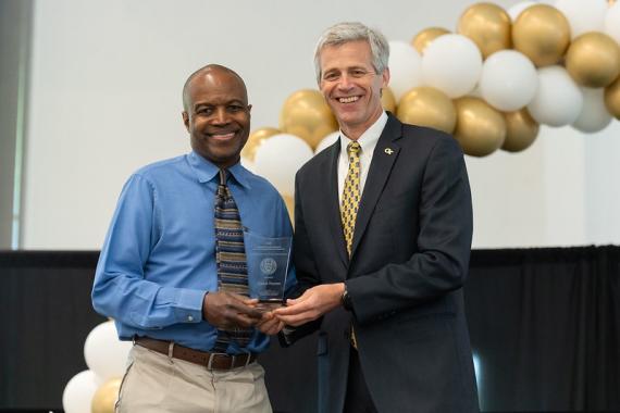 Comas Haynes, Ph.D. (left) receives the Outstanding Achievement in Research Engagement and Outreach Award.