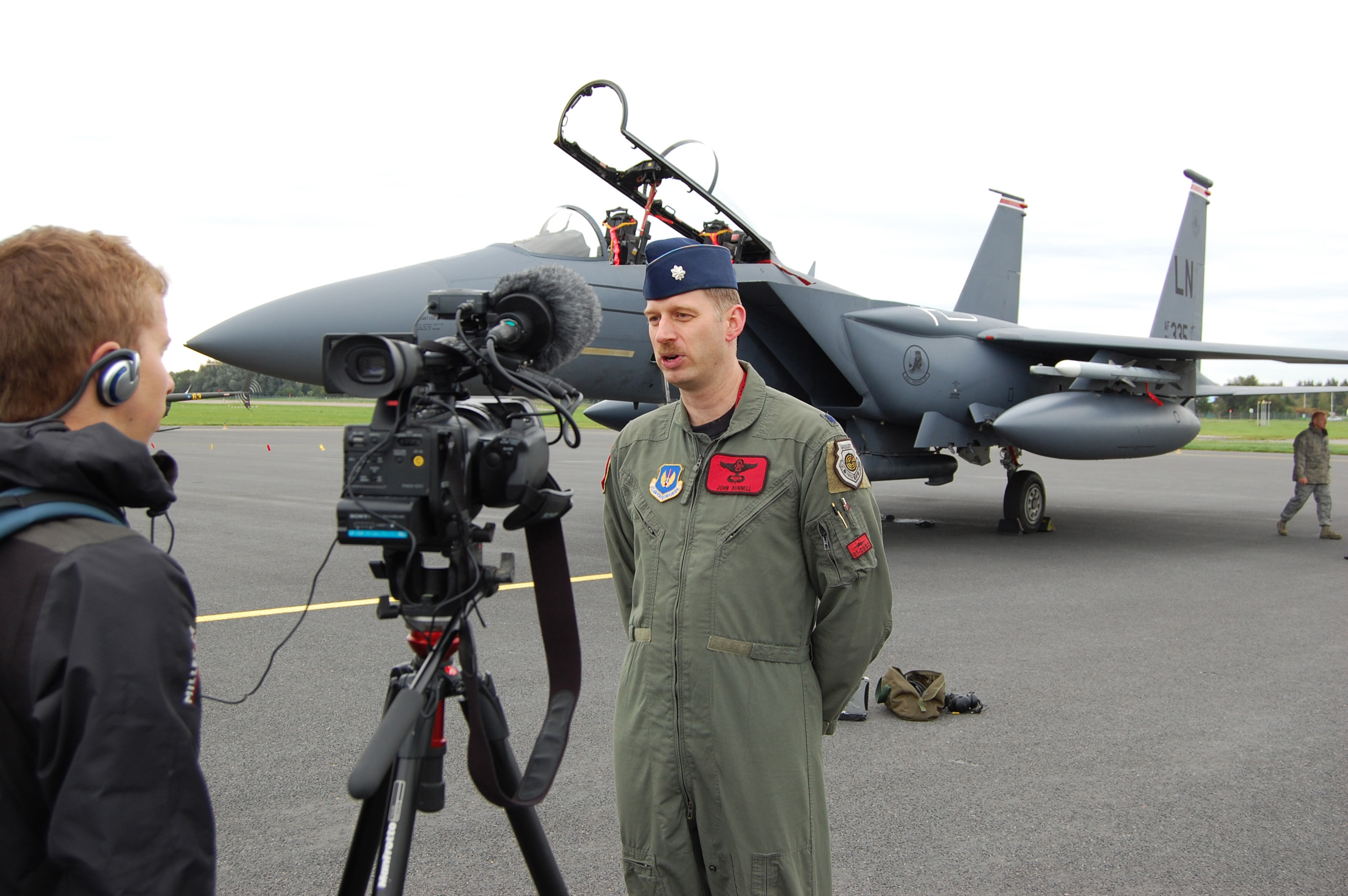 Bugs image in front of a plane and a camera facing him as he talks to the camera