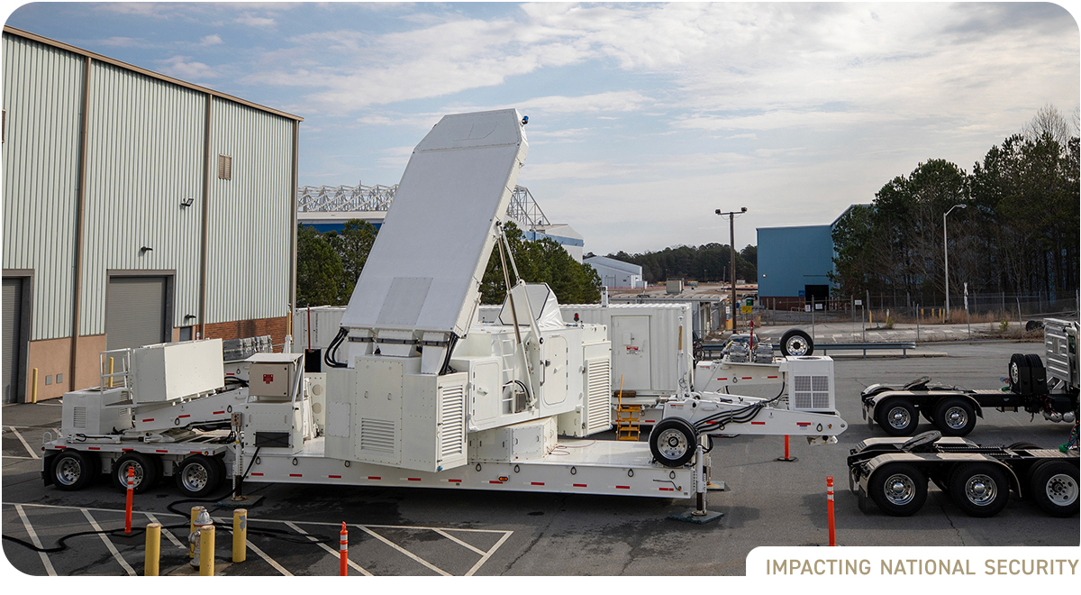 Large white radar system mounted on flatbed semi trailer awaiting transport