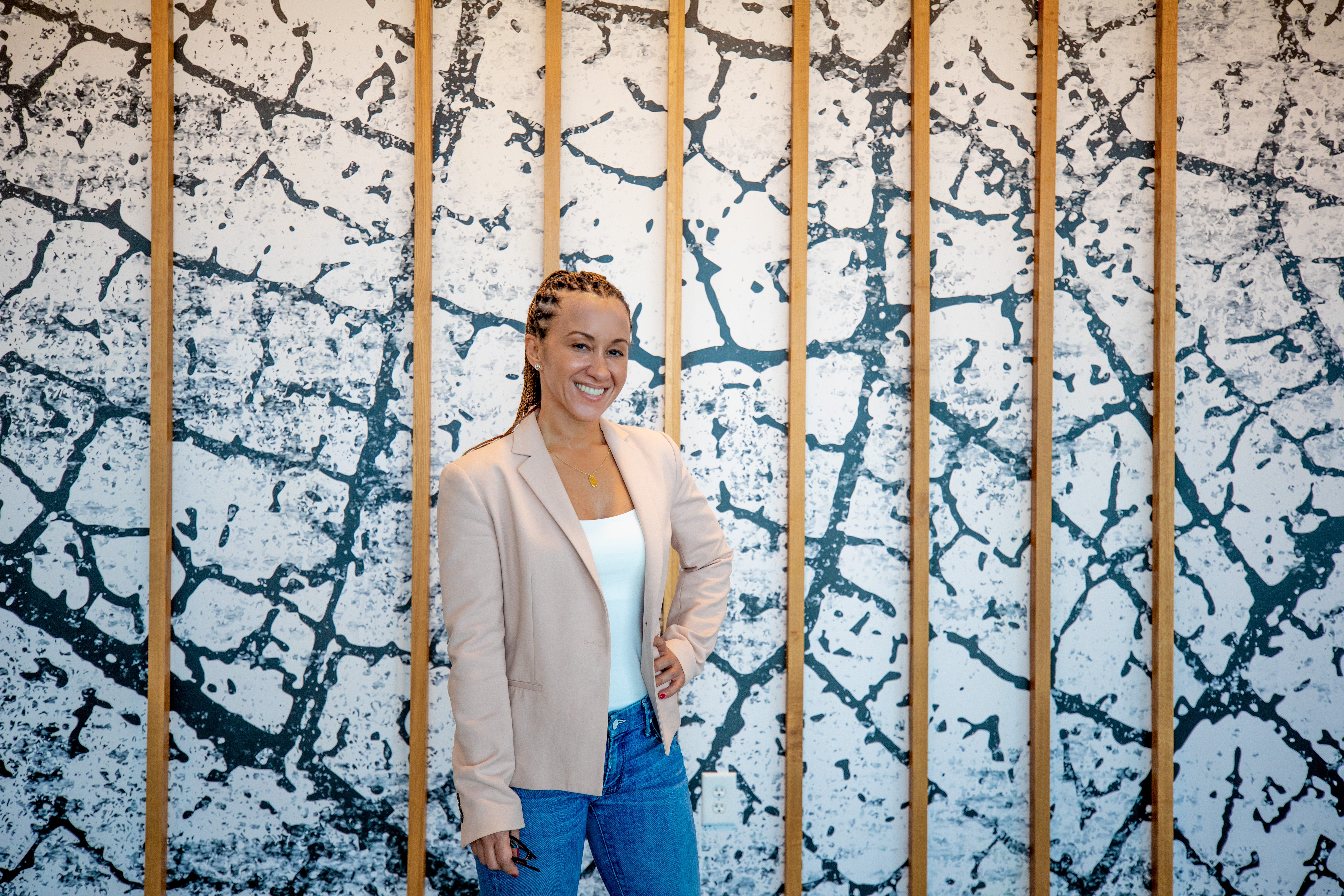 Danika Tynes stands in front of a black and white wall. (Credit: Branden Camp)