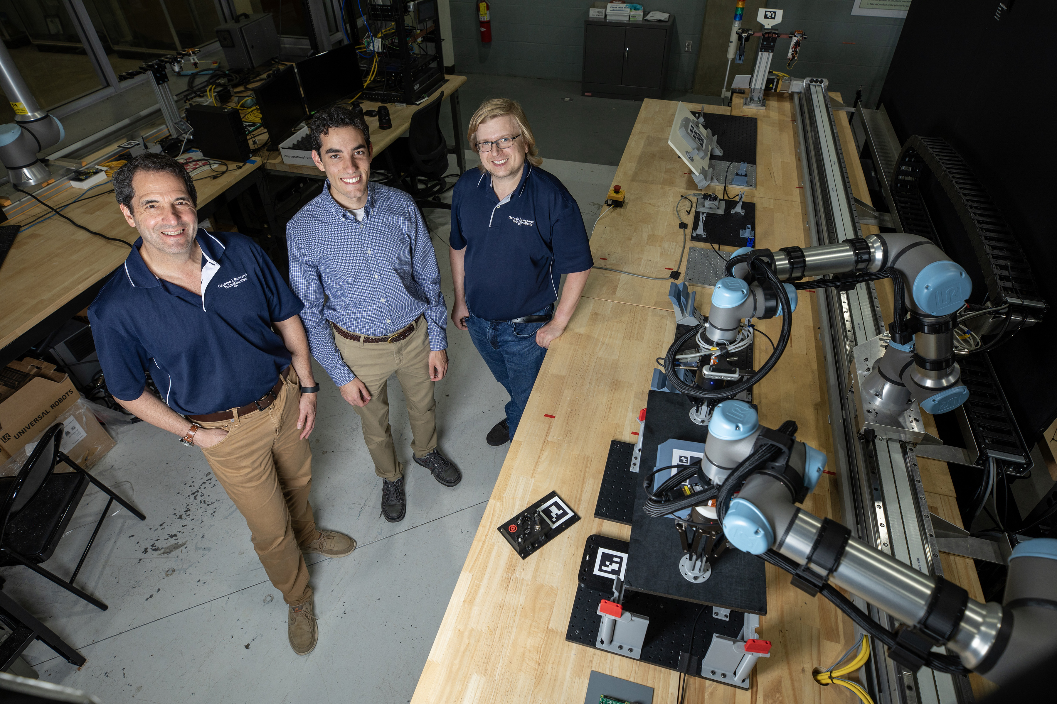 Researchers pose with a pair of robots.