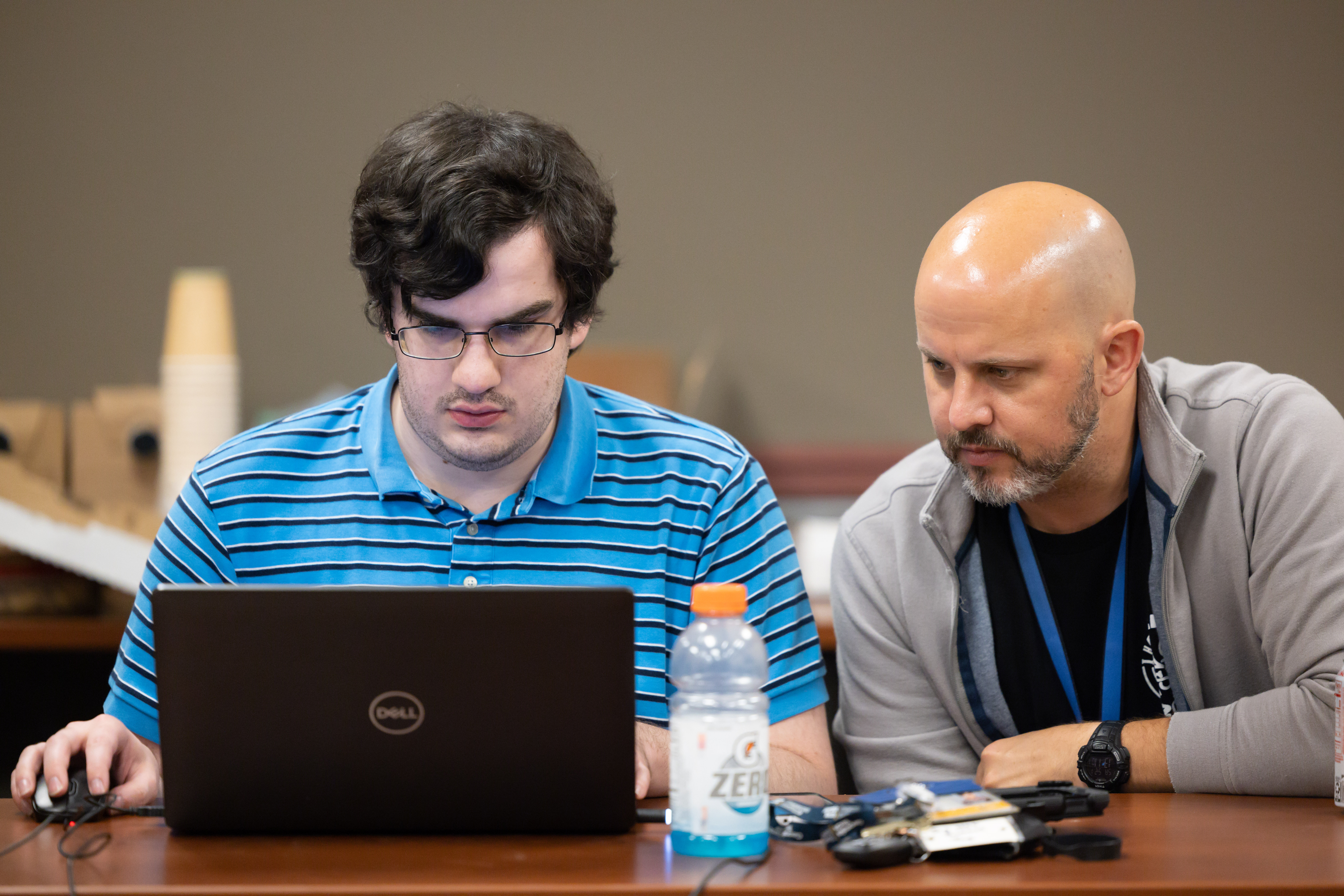 GTRI Principal Research Engineer Chris Roberts helps a student during a hackathon competition.