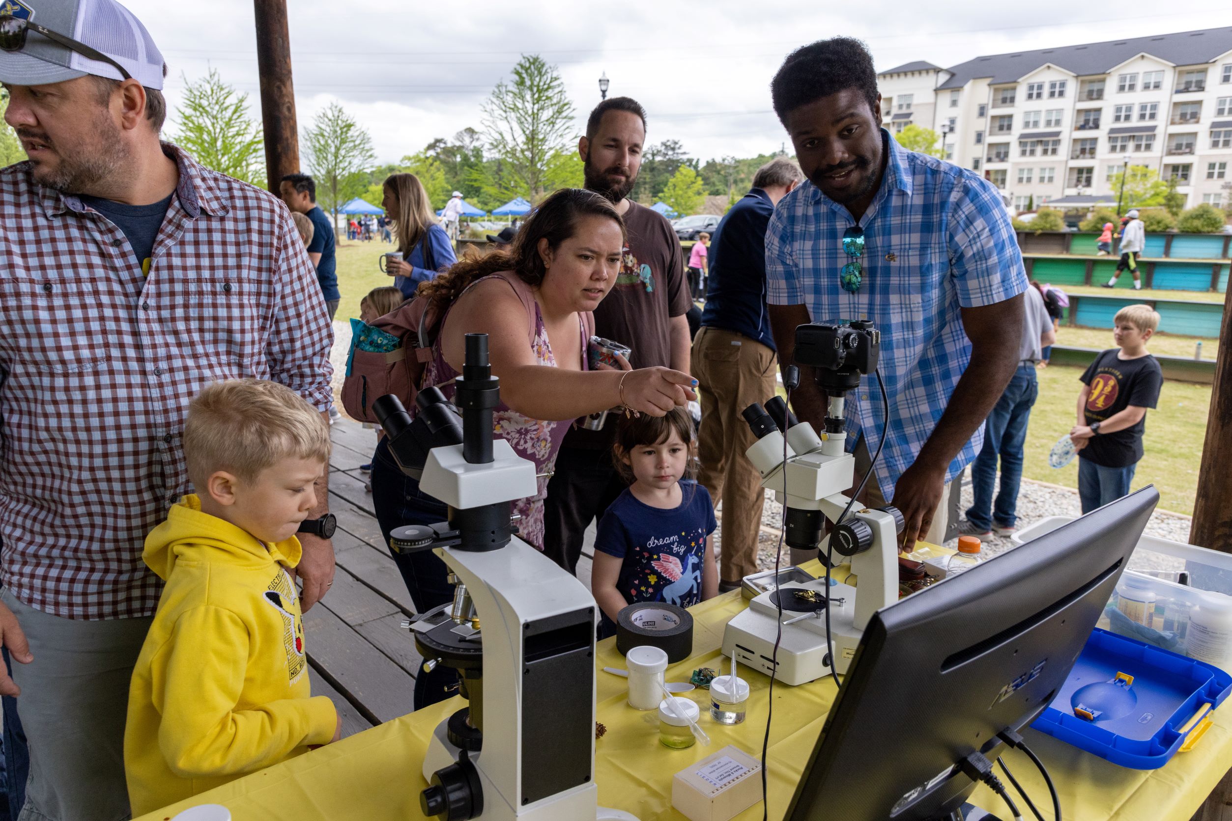 A group looking through microscopes set up by GTRI at the Science Day in the Park.