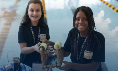 Two students pose with underwater robot