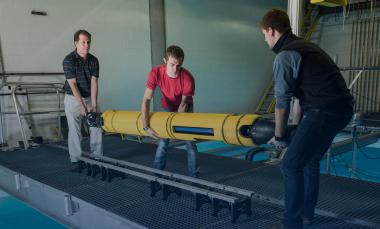 GTRI principal research engineer Mick West, Earth and Atmospheric Sciences graduate student Jacob Buffo, and Mechanical Engineering undergraduate Matthew Meister handle the 210-pound Icefin  (Credit: Rob Felt)