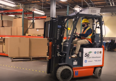A photo of a forklift driver in a warehouse. 