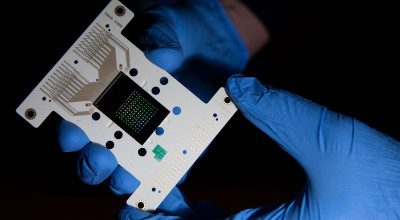 Gloved hands of research holds microchip device