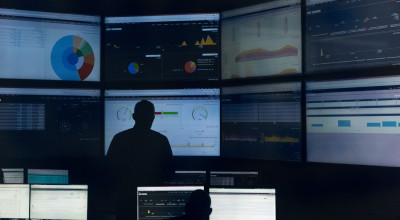 Researcher in front of eight monitors