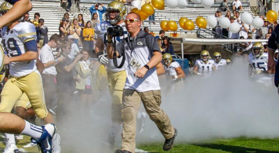 Danny Karnik runs out of the tunnel with the football team to capture a photo during the game against UGA in 2015 (Photo by Brett Davis).