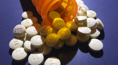 Shows-a-bottle-of-pills-being-spilled-on-a-blue-background
