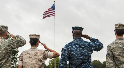 Soldiers saluting the American flag. 