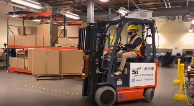 A photo of a forklift driver in a warehouse. 