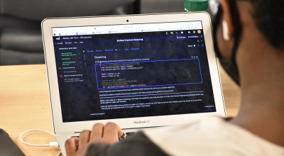 A student works on his laptop. 