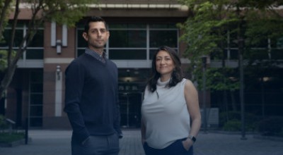 A photo of two GTRI researchers standing in front of a building. 
