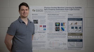 An image of a GTRI researcher standing in front of his research poster.