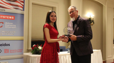 Isabella Reyna--accepting the award from Todd Kastle at the Association of Old Crows (AOC) Christmas party.